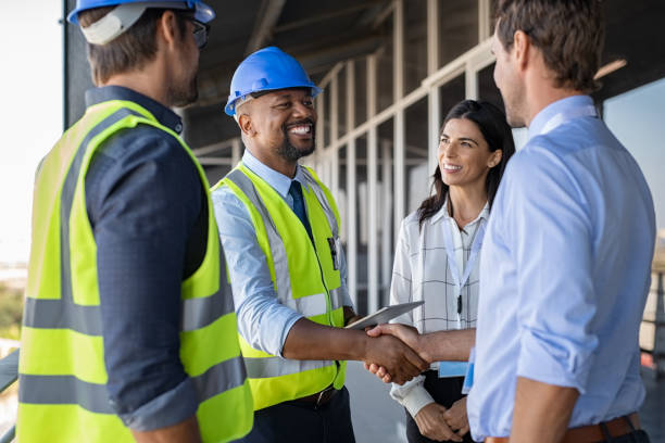Smiling engineer shaking hands at construction site